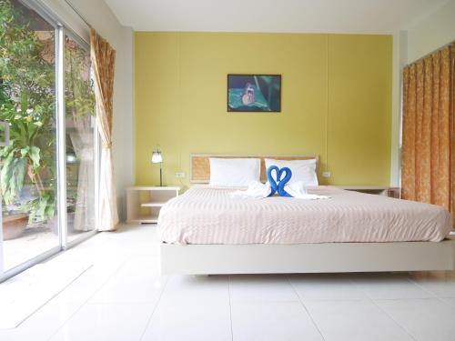 a bedroom with a bed with a blue ribbon on it at Forest Bungalows & Mama's Restaurant in Chalong
