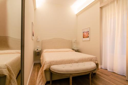 a small bedroom with two beds and a mirror at Il giardino di Pantaneto Residenza D'Epoca in Siena