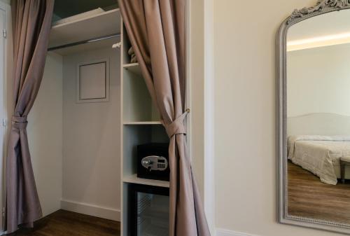 a mirror in front of a bedroom with a bed at Il giardino di Pantaneto Residenza D'Epoca in Siena