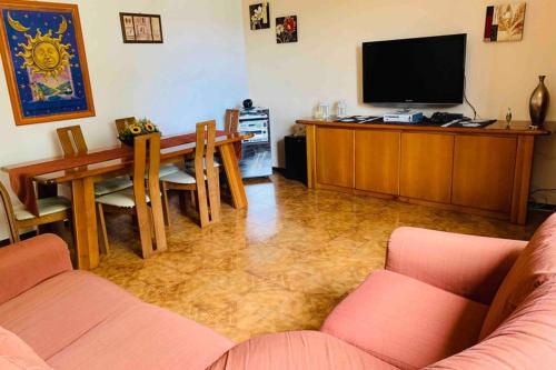 a living room with a table and a television at Flowery House in Miglianico