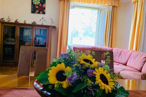 a living room with a table with a bouquet of flowers at Flowery House in Miglianico