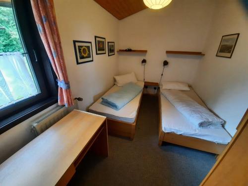 Pokój z 2 łóżkami i oknem w obiekcie Ferienhaus Robinson 113 w mieście Waldbrunn
