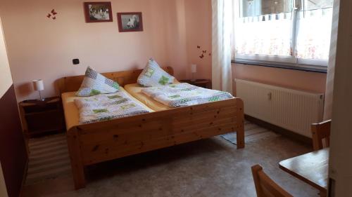 BergにあるMühlbachhofのベッドルーム1室(木製ベッド1台、枕付)