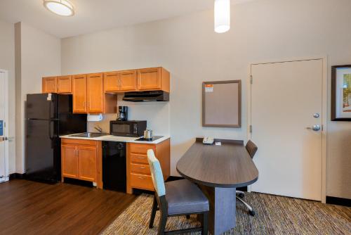 a small kitchen with a table and a refrigerator at Candlewood Suites Medford by IHG in Medford