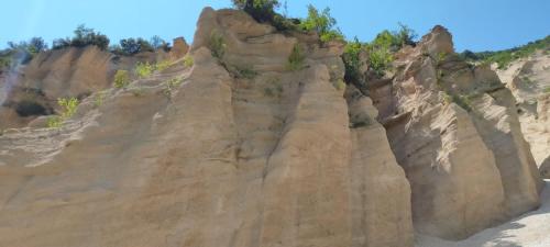 a rocky cliff with trees on top of it at HOTEL B&B RESORT Fonte La Castellana in Sarnano