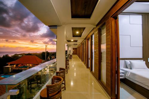 balcone di un hotel con letto e tramonto di Nusa Sedayu Hotel By Ocean View a Nusa Penida