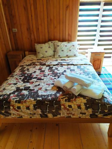 a bed in a wooden room with towels on it at Lisnyi in Mizhhirʼʼya