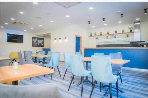 restauracja z niebieskimi krzesłami i stołami w pokoju w obiekcie AI HOSTEL w Splicie