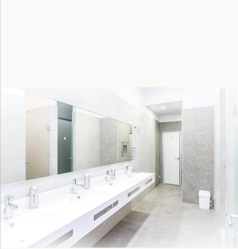 a bathroom with three sinks and a large mirror at AI HOSTEL in Split