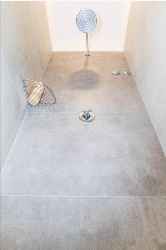 a shower with a tile floor with a fan at AI HOSTEL in Split