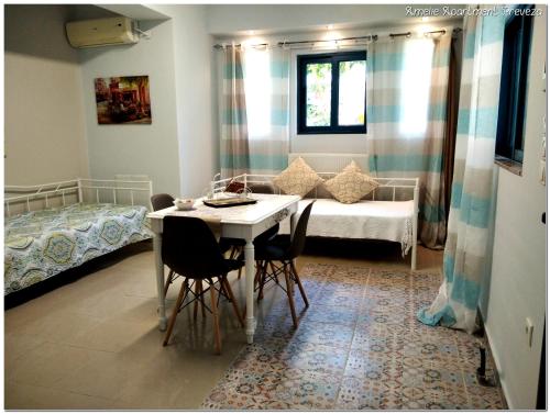 a room with a table and chairs and a bed at Amelie Apartment in Preveza
