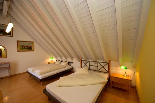 two beds in a room with a ceiling at Landgasthof Werdenberg in Werdenberg
