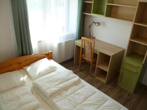 a bedroom with a bed and a desk and a chair at Klimatyczny Domek - Apartamenty & Noclegi in Sławęcin