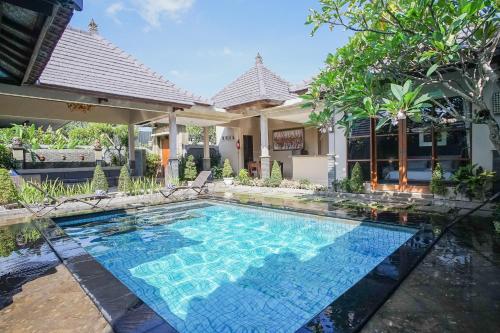 a swimming pool in front of a house at Dura Villas Bali at Kerobokan in Kerobokan