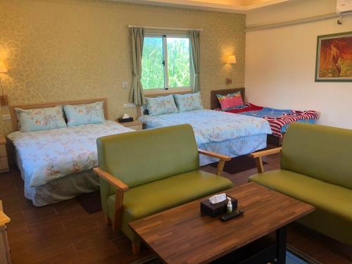 吉安的住宿－四季軒民宿，酒店客房设有两张床和一张桌子。