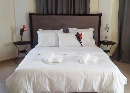 a white bed with two towels on top of it at La Vatura in Gialova