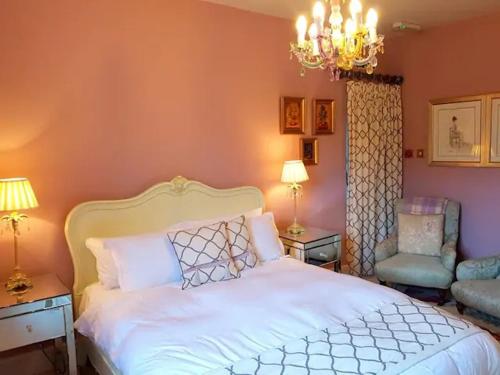 a bedroom with a white bed and a chair at No 6 The Square Tearooms & Accommodation in Buxton