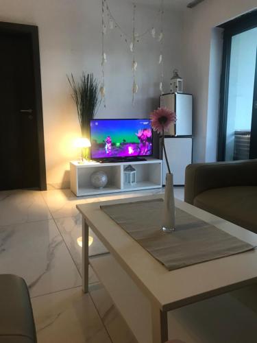 a living room with a tv and a table at Ive‘s Gardenia Seaside in Dziwnów