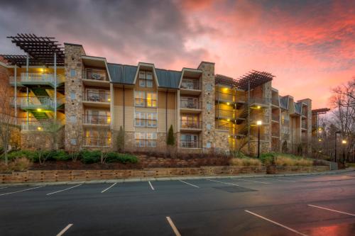 an apartment building with a parking lot at sunset at The Residences at Biltmore - Asheville in Asheville