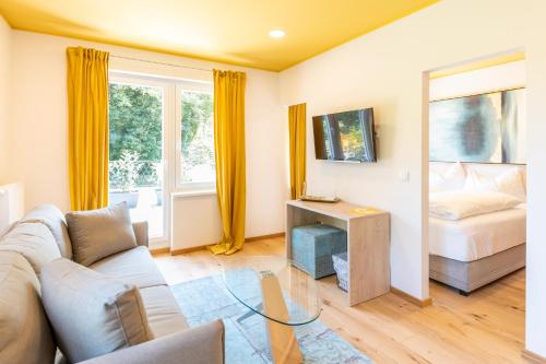 a living room with a couch and a bed at Boutiquehotel Caravella Velden by S4Y in Velden am Wörthersee