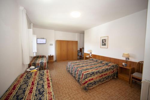 a hotel room with two beds and a tv at Hotel Santa Caterina in Marina di Campo