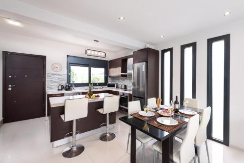 a kitchen and dining room with a table and chairs at Ixia Breeze 2 in Ixia