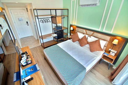 a bedroom with a large bed and a mirror at Club Big Blue Suit Hotel - All Inclusive in Alanya