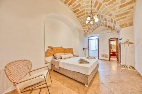 um quarto com uma cama e uma cadeira num quarto em Corte Anibaldi Apartment em Lecce