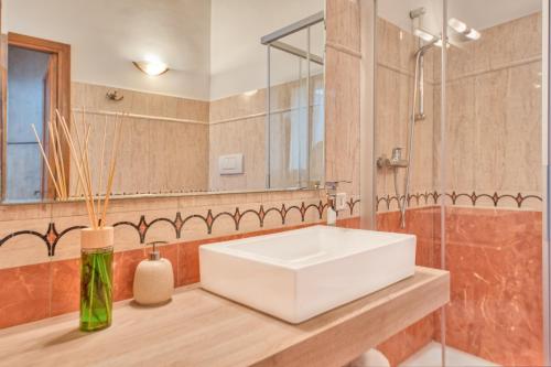 bagno con lavandino bianco e specchio di Corte Anibaldi Apartment a Lecce