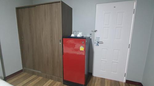 einen roten Kühlschrank in einem Zimmer neben einer Tür in der Unterkunft Chai Style Mansion in Ban Khlong Bang Bon