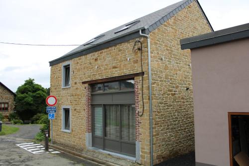 a brick building with a large window on it at L’Ancienne Grange 1916 in Chevetogne