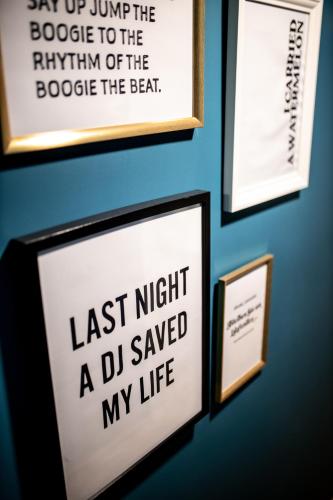 a wall with framed pictures and a sign on a wall at Boutiquehotel Caravella Velden by S4Y in Velden am Wörthersee