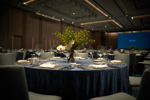 a table with a blue table cloth and a vase of flowers at Signiel Busan in Busan