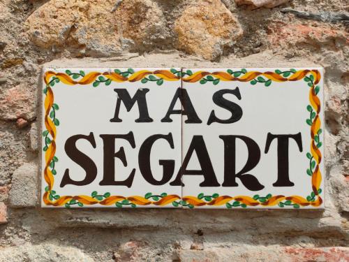 a sign on a brick wall that says was spaghetti at Mas Segart in Santa María de Palautordera