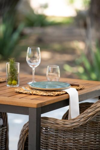 a picnic table with two wine glasses on it at Can Arabí - Adults Only in Ibiza Town