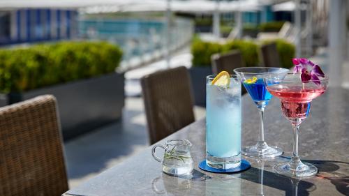 two cocktails on a table next to a pool at Signiel Busan in Busan