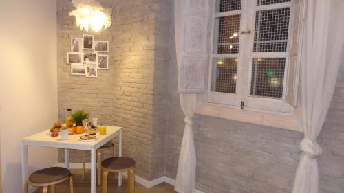 einen Tisch und Stühle in einem Zimmer mit Fenster in der Unterkunft Bonito Alojamiento in Valencia