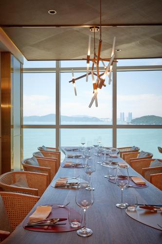 a long dining room with a long table with wine glasses at Signiel Busan in Busan