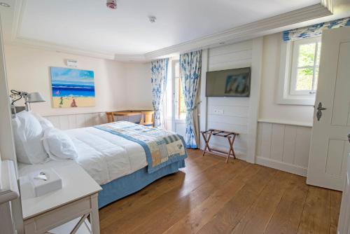 a bedroom with a bed and a table and a window at Villa Cécile in Yvoire