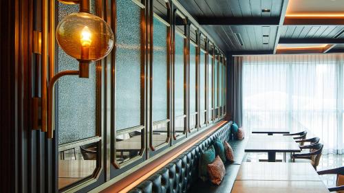 a dining room with tables and chairs and a window at Signiel Busan in Busan
