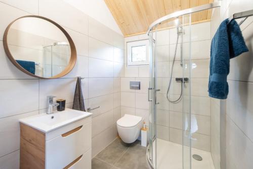 a bathroom with a shower and a sink and a mirror at Domek rodzinny in Ustronie Morskie