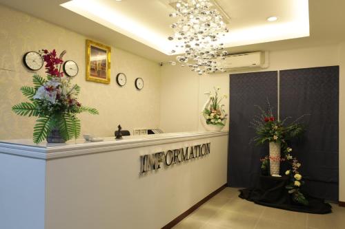- un dressing avec une coiffeuse et des fleurs sur le mur dans l'établissement Kerepiman Boutique Hotel, à Khao Kho