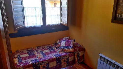a small bedroom with a bed and a window at Posada La Vieja Escuela in San Roque de Ríomiera