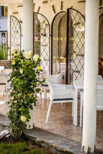 a group of white chairs and tables on a patio at Boutiquehotel Caravella Velden by S4Y in Velden am Wörthersee