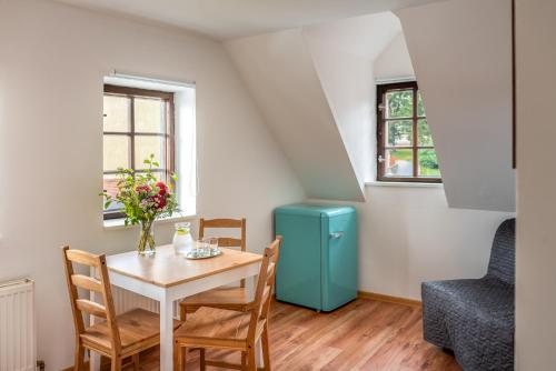 a dining room with a table and a blue refrigerator at Dobrý Kanec - Hostinec in Mělník