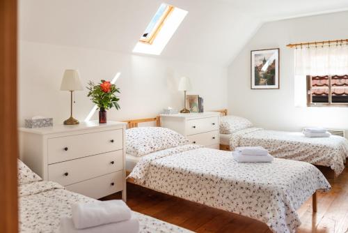 a bedroom with three beds and a dresser with flowers at Dobrý Kanec - Hostinec in Mělník