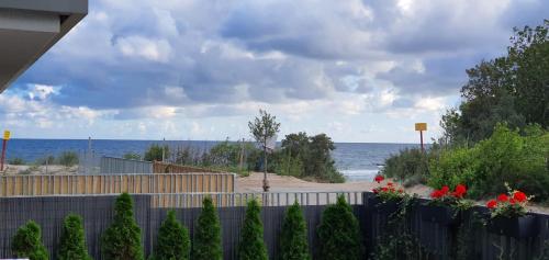 a view of the ocean from behind a fence at Ive‘s Gardenia Seaside in Dziwnów