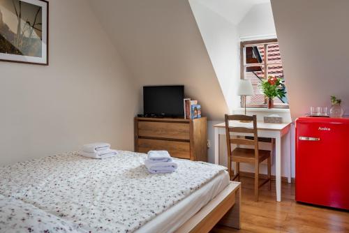 a bedroom with a bed and a desk and a red refrigerator at Dobrý Kanec - Hostinec in Mělník