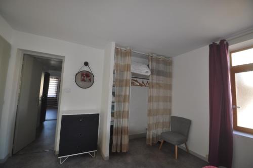 1 dormitorio con cama, silla y espejo en sassenage au pied du Vercors 2 appartements, en Sassenage