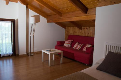 a living room with a red couch and a table at Posada de Suesa in Suesa
